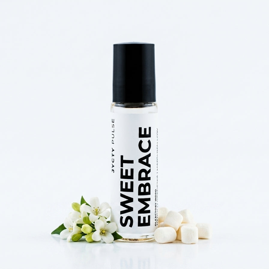 A clear 10ML bottle with a black cap and a white label reading 'SWEET EMBRACE' styled with small white blossoms and white candy cubes on a clean white background.