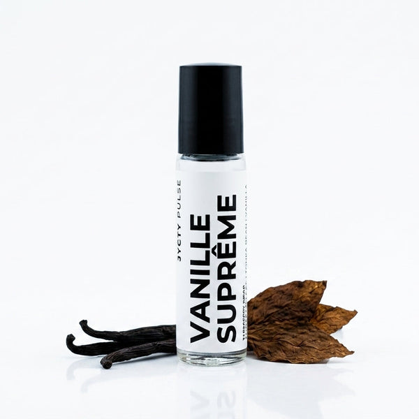 A clear cylindrical roller bottle with a black cap and a white label reading 'VANILLE SUPRÈME' vertically, styled on a white background with vanilla beans and dried brown leaves beside it.