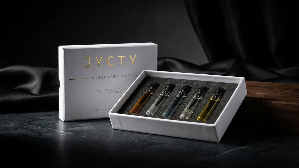 JYCTY discovery set with five small perfume oil bottles on a dark surface